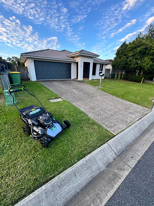 commercial battery lawn mowing job in Raceview mowing residential home